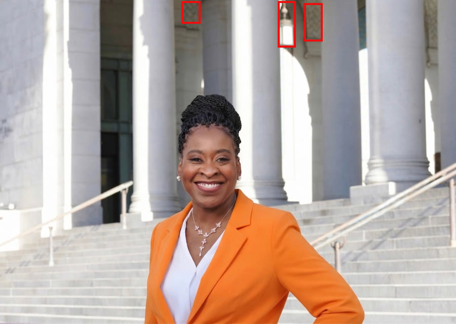 Renita Duncan's campaign photo on stone steps, with red boxes marking a hanging lantern and patterned tile on the building behind her.